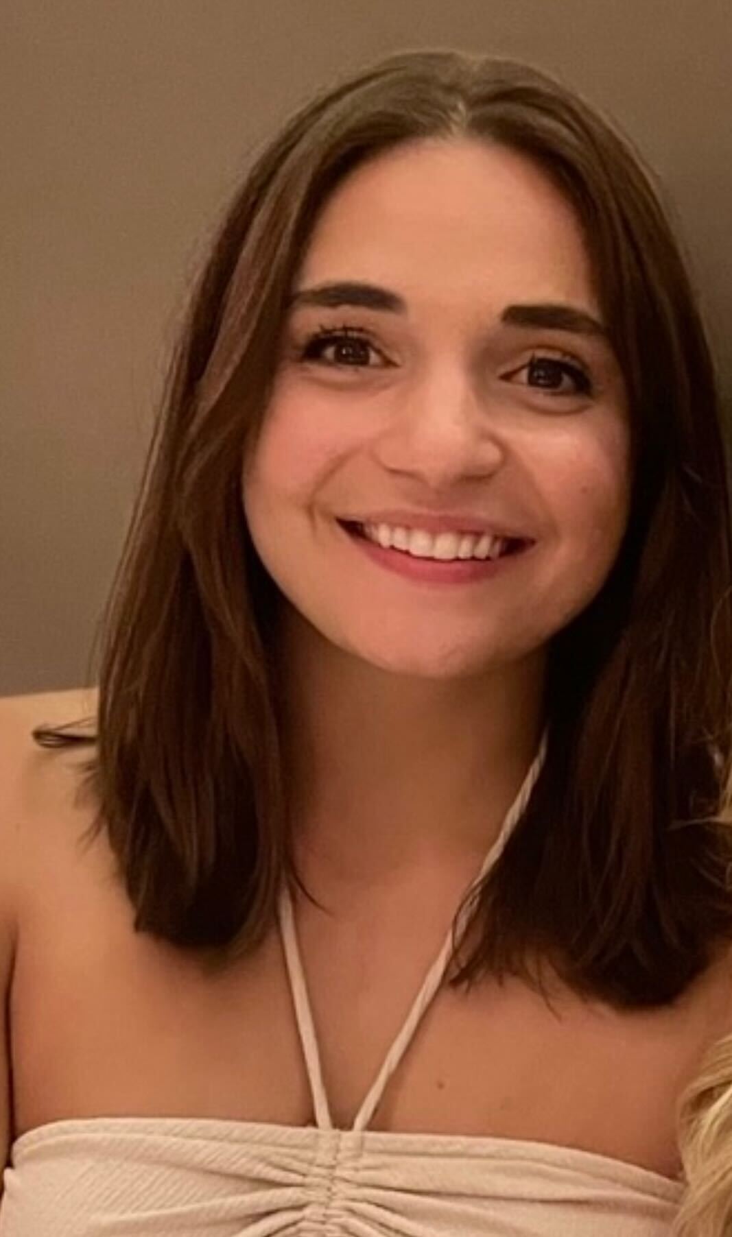 A headshot of a woman with brown hair smiling at the camera