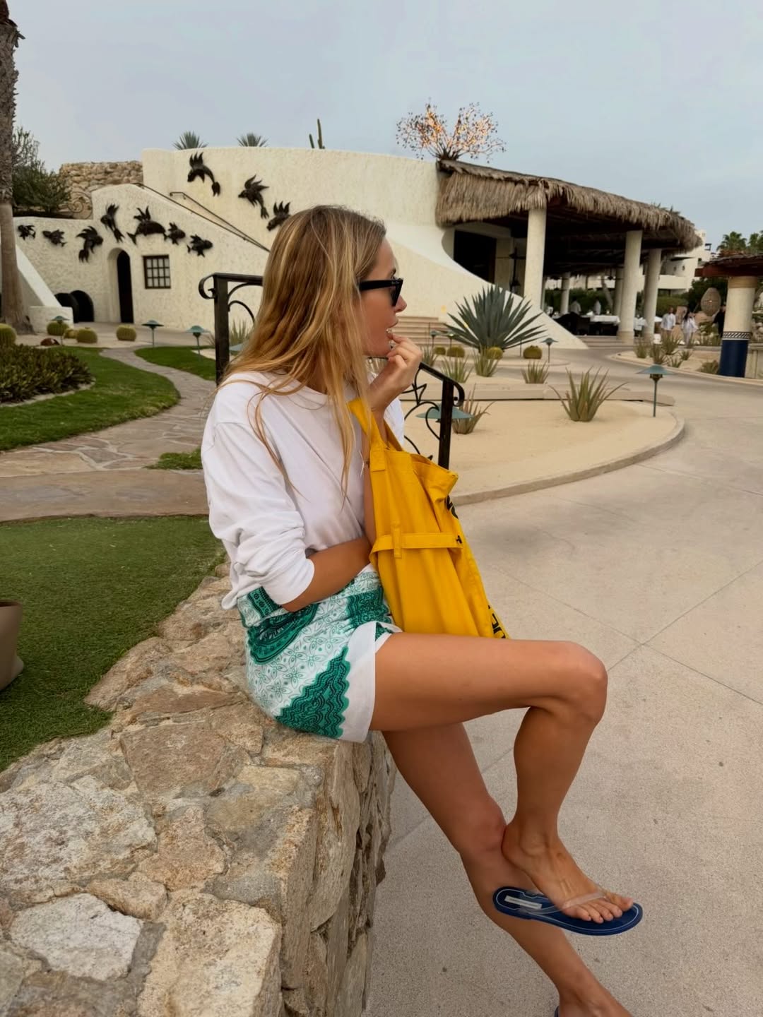 Courtney Grow wearing cobalt-blue Christopher Esber flip-flops