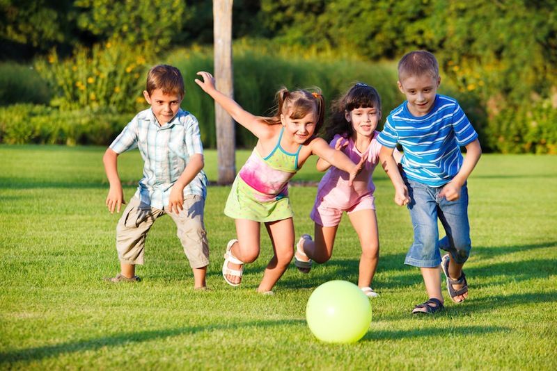 Children play and chase after a ball.