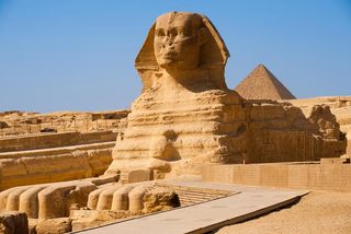 The full profile of the Great Sphinx with the pyramid of Menkaure in the background in Giza, Egypt