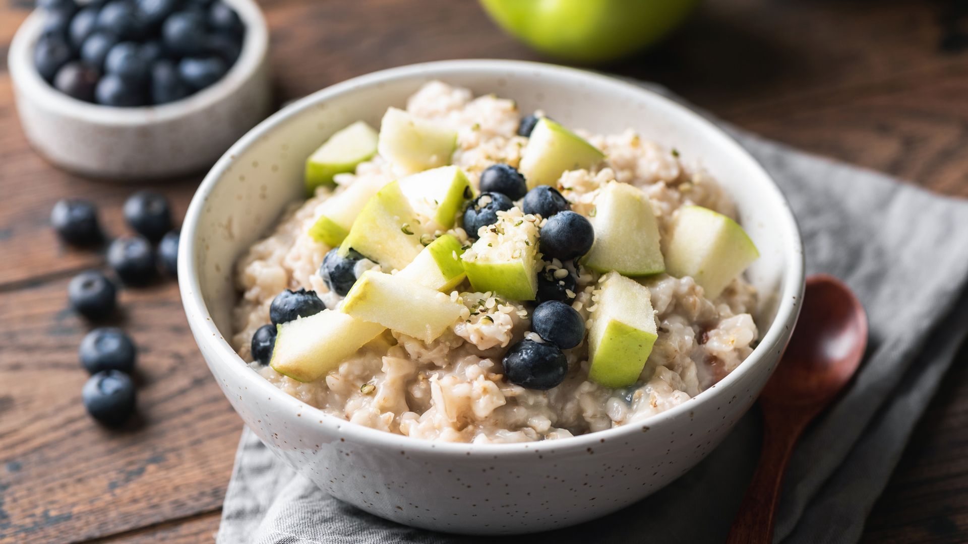 bowl of oatmeal topped with blueberries and apple