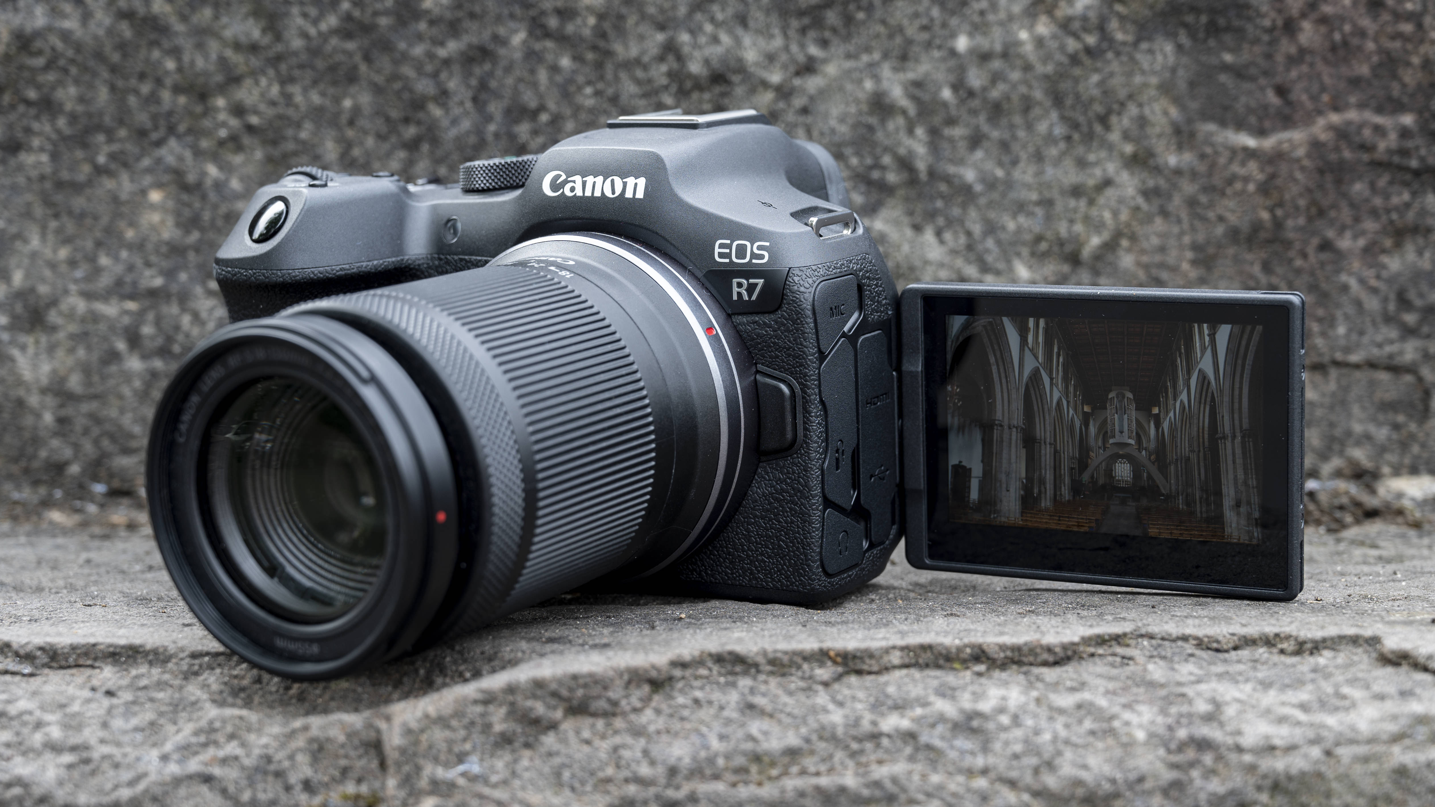 Canon EOS R7 камера сидит на каменной ступеньке
