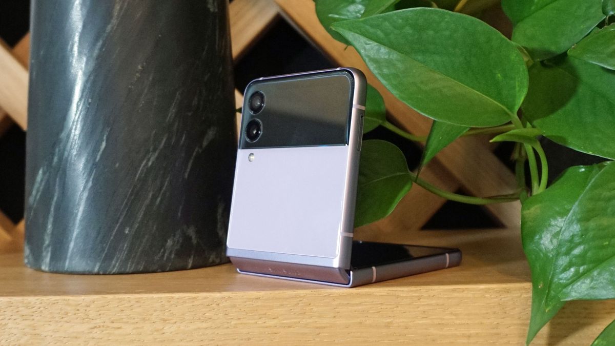 A Samsung Galaxy Z Flip 3 half folded, on a wooden surface