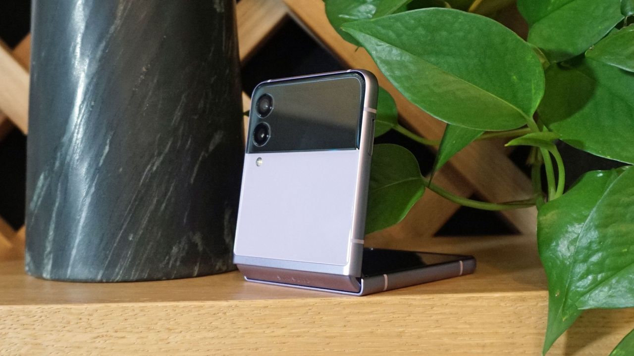 A Samsung Galaxy Z Flip 3 half folded, on a wooden surface