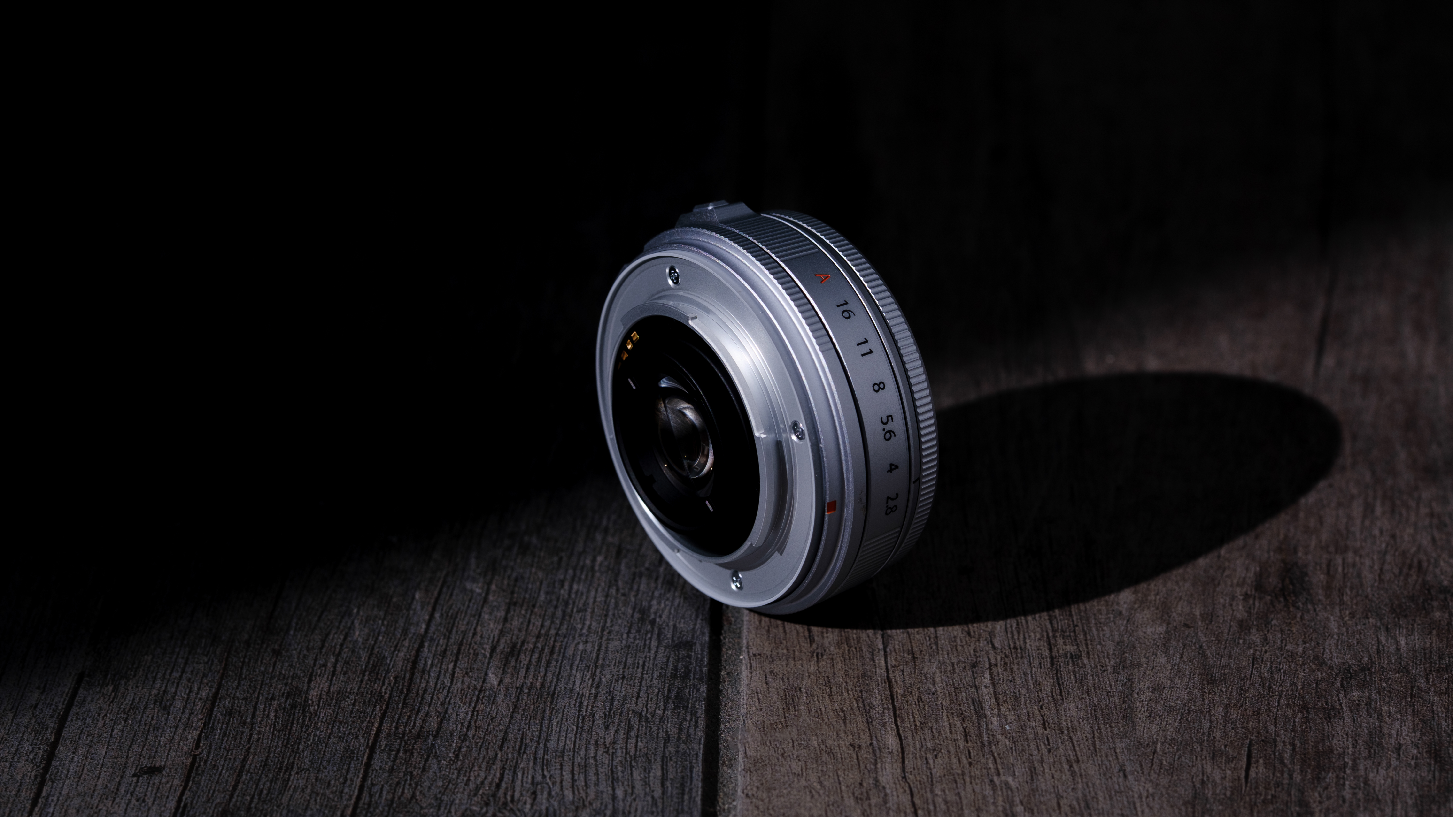 The Fujifilm XF 23mm f/2.8 R WR on a gray wood-like surface