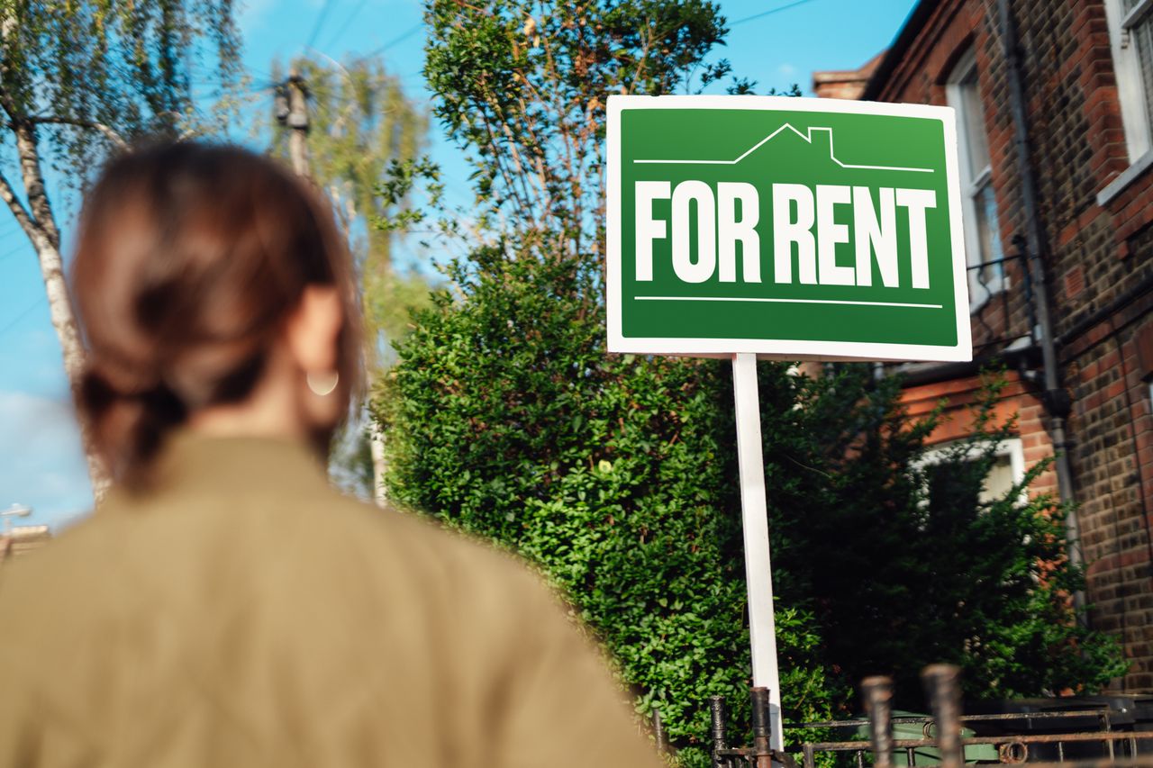 Woman looking at for rent sign