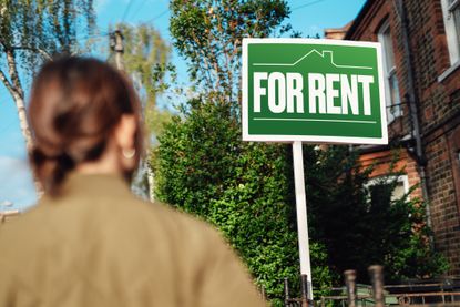 Woman looking at for rent sign