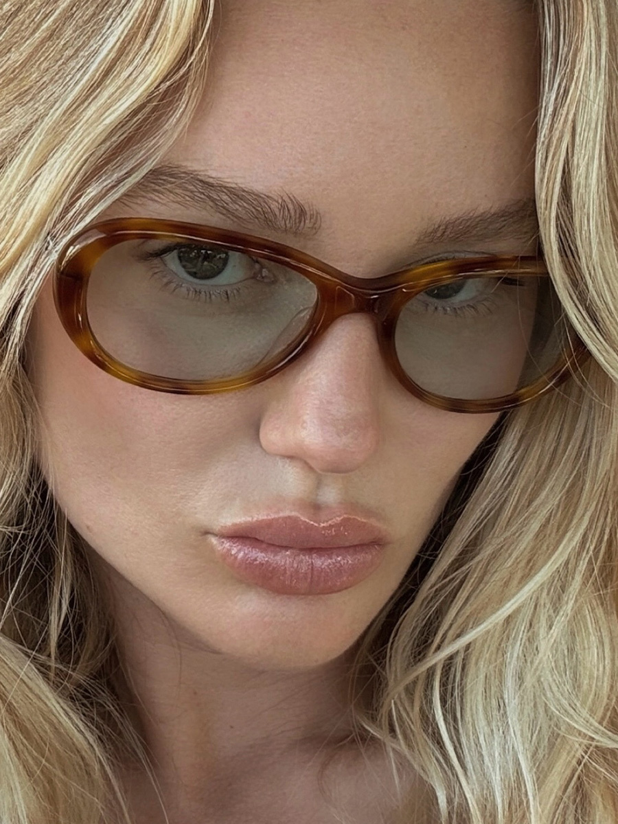 Megan Adelaide poses with sun-kissed skin and oversized Maison Margiela shades