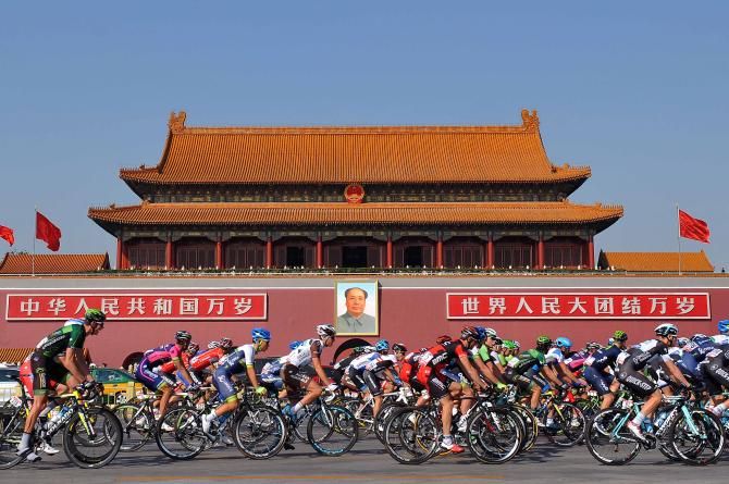 The peloton passes in front of the picture of Chairman Mao