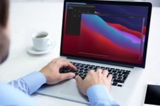 Man sat at desk working on laptop