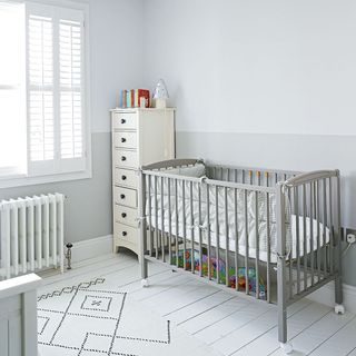 modern white nursery with grey painted cot