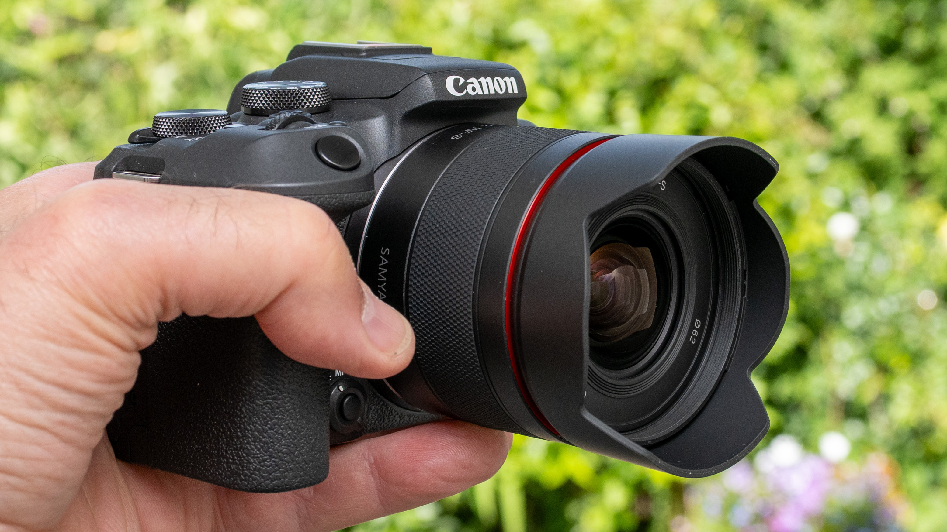 LK Samyang AF 12mm f/2 RF-S product shot lens held in hand