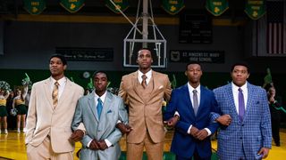 Scoot Henderson as Romeo Travis, Caleb McLaughlin as Lil Dru Joyce III, Mookie Cook as LeBron James, Avery S. Wills, Jr. as Willie McGee and Khalil Everage as Sian Cotton standing arm in arm on a basketball court in Shooting Stars