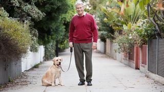 Senior man walking his dog in an alley