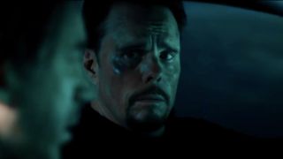 Kevin Dillon driving at night with a worried, bruised face in A Day To Die.