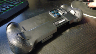 Scuf Nomad review image showing the controller holding an iPhone which is lying screen down on a desk