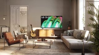 The LG A2 OLED TV pictured in a light living room displaying a green and pink pattern.