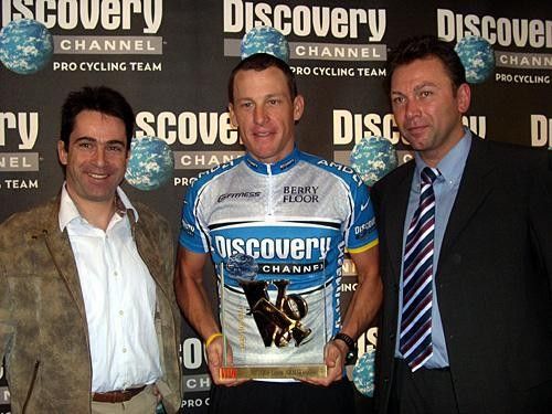 Clad in his new Discovery Channel team strip Lance Armstrong (C) is honored with the 2004 Velo d'Or, presented by Velo Magazine's Editor Gilles Conte (L) while Discovery Channel team sports director Johan Bruyneel (R) looks on.