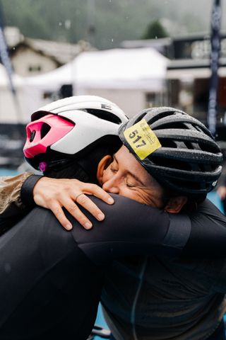 Two riders hug at the finish