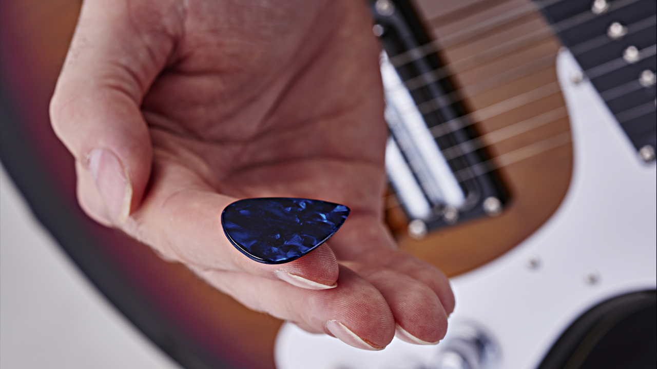 Hand holding a guitar pick