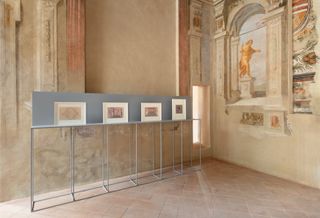 Photographs by Luigi Ghirri for Marazzi, shown on a light blue display inside Palazzo Ducale, Sassuolo. The Palazzo's frescoed walls are visible behind the display