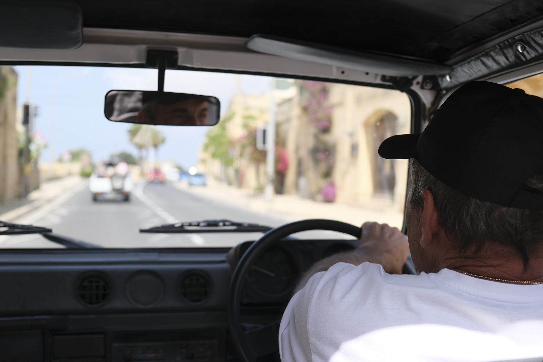 Portrait of driver at the wheel from behind with view in front in soft focus
