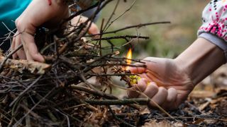 Children's hands make a fire with a lighter flame