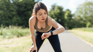 Woman checking smart watch during run