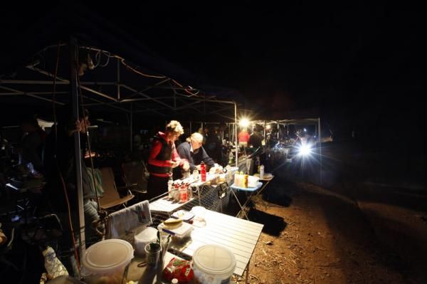 The helpers in the feed zone get ready for a long night, with some light rain falling.