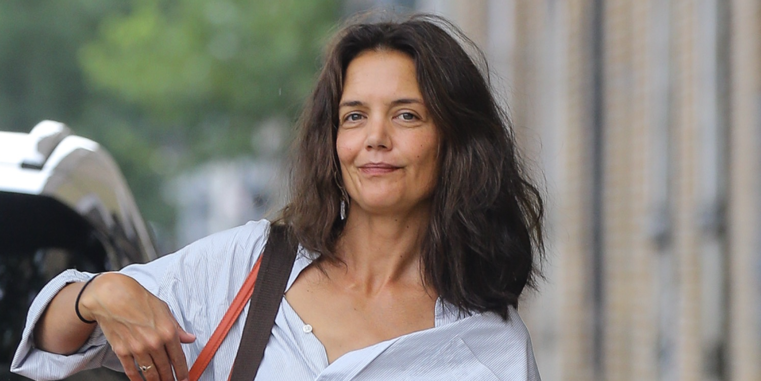 Katie Holmes was spotted running errands in New York City wearing a white shirt, mom jeans, and black flats, Louis Vuitton and Tod's bags, along with an orange tote.