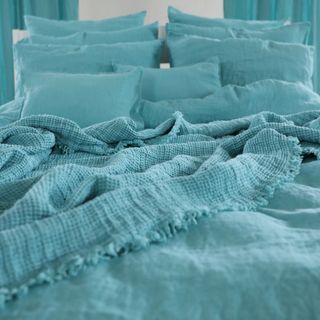 bedroom with aqua blue colour bedlinen and cushions