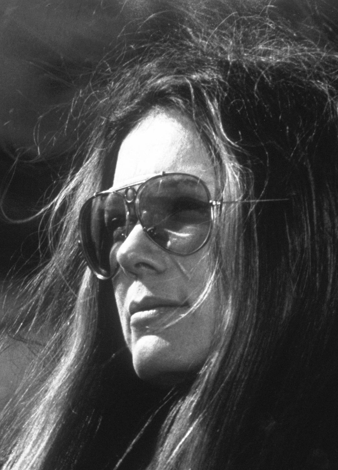 Feminist Gloria Steinem wearing her trademark aviator sunglasses during a TV interview show.