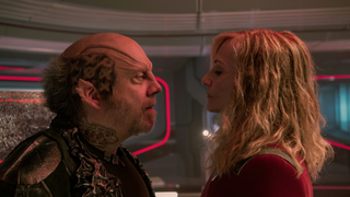 An alien male confronts a blonde starship captain