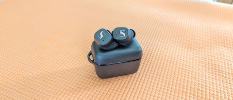 The Sennheiser Sport True Wireless wireless earbuds sitting atop of charging case