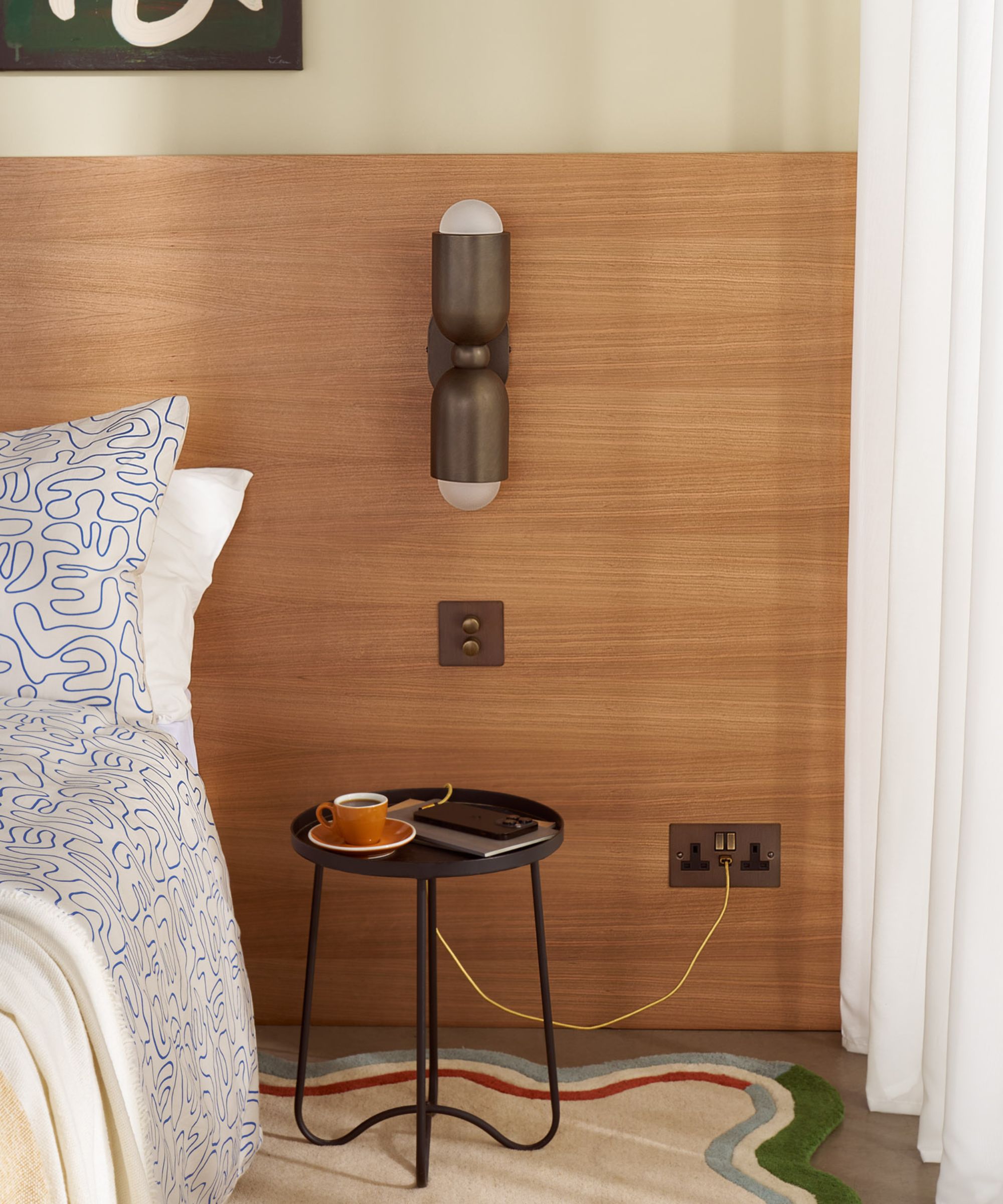 A bedside wall light on a wooden headboard