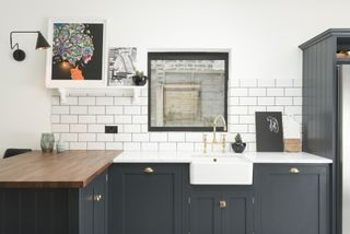 small kitchen with peninsula with wooden countertop joining marble countertop and metro tiles backsplash