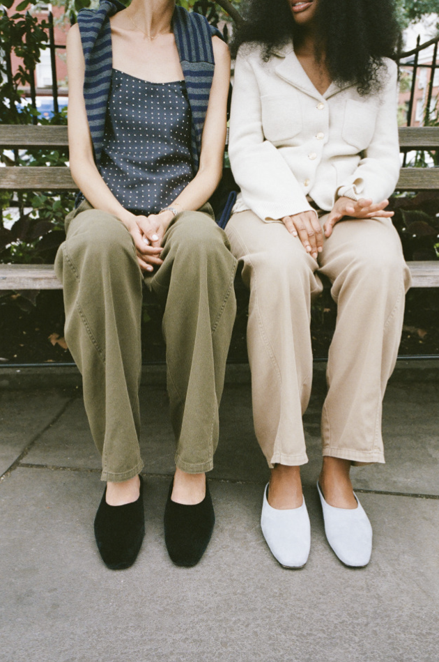 two models sitting on a bench wearing Alex Mill for Margaux mules