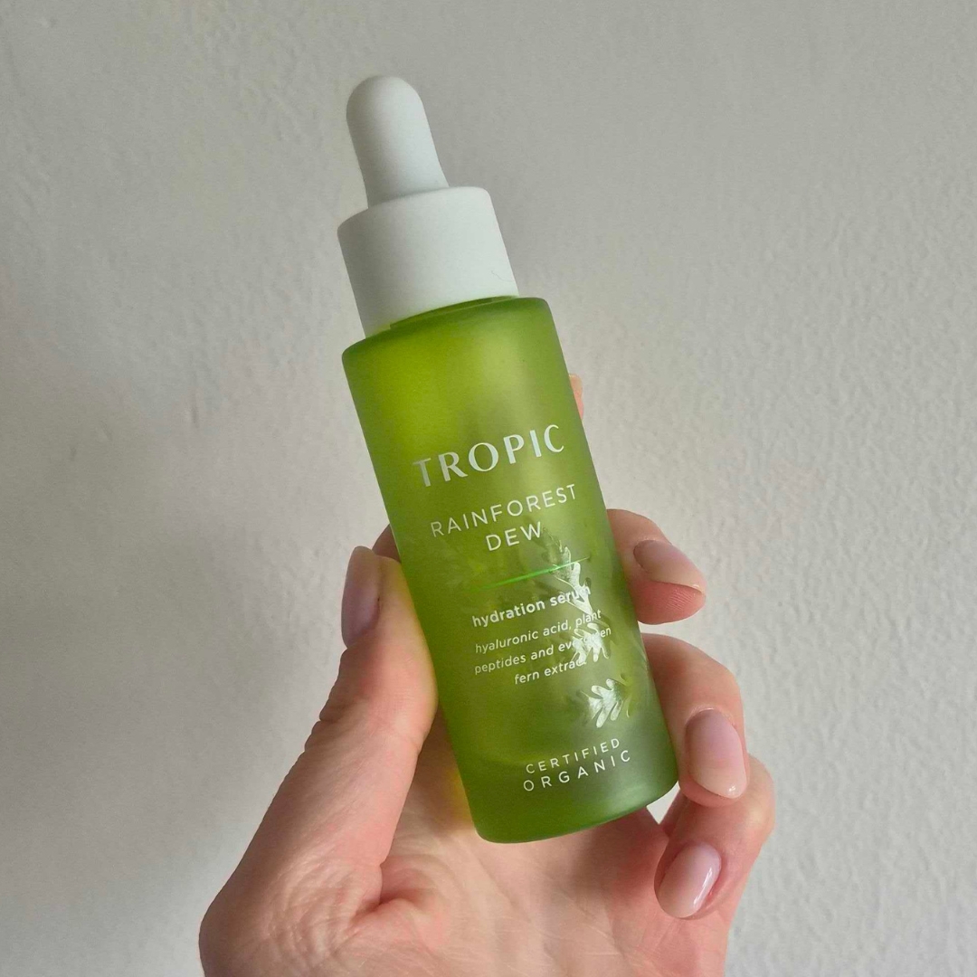 Hand holding empty bottle of the Tropic Skincare Rainforest Dew Hydration Serum