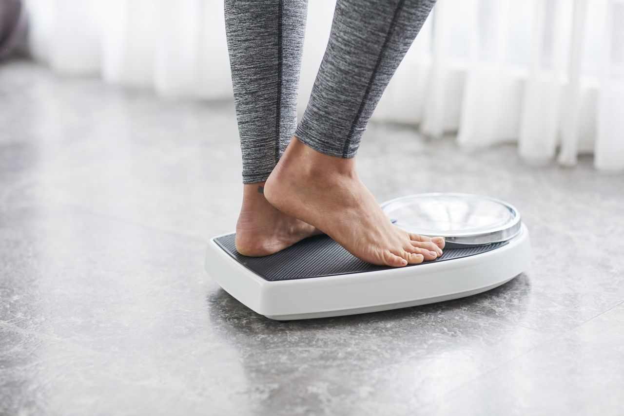 Winter weight gain: woman standing on scales