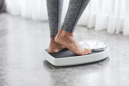 Winter weight gain: woman standing on scales