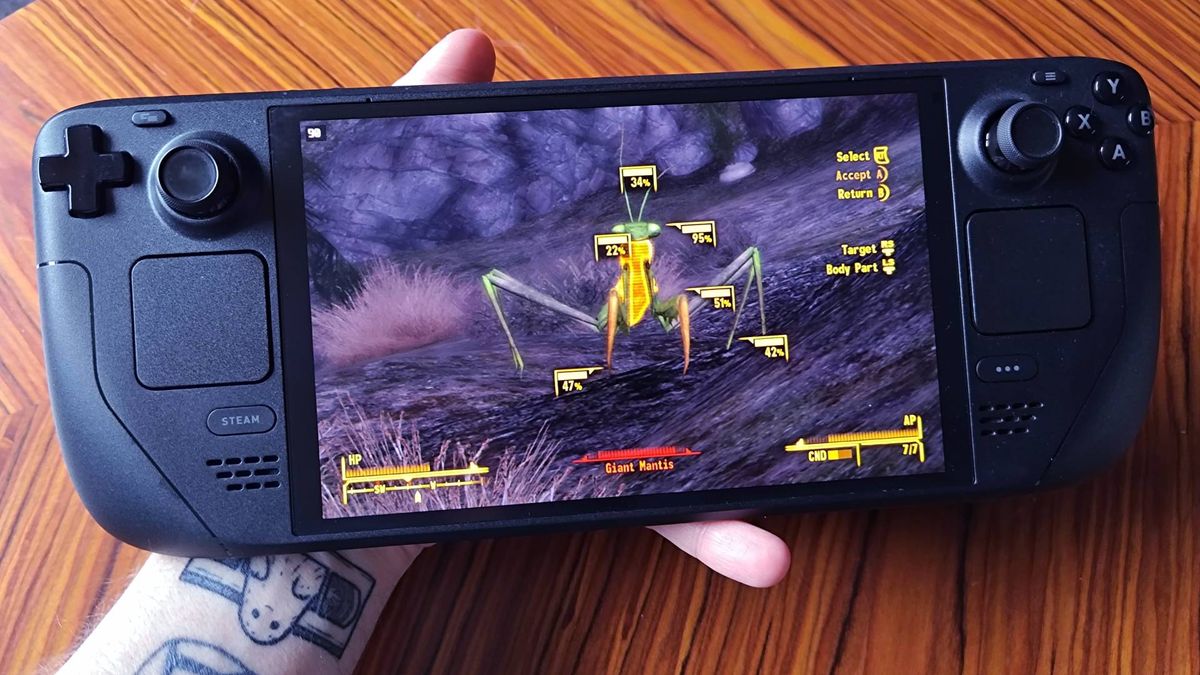 Hand holding Steam Deck OLED with Fallout New Vegas gameplay on screen featuring VATS targeted Mantis.