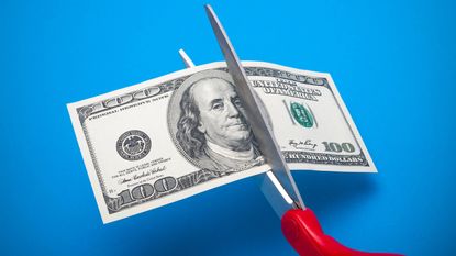 A 100-dollar bill being cut in half