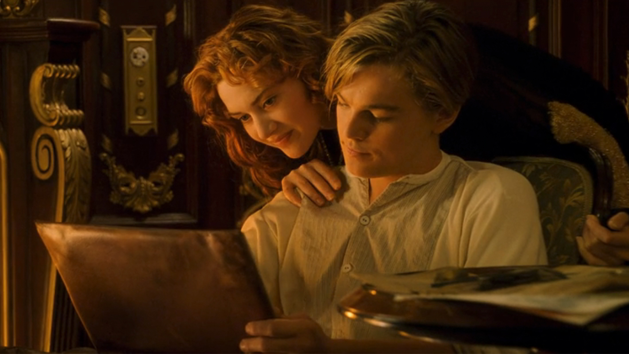 Kate Winslet looking over Leonardo DiCaprio's shoulder as he draws her picture in Titanic