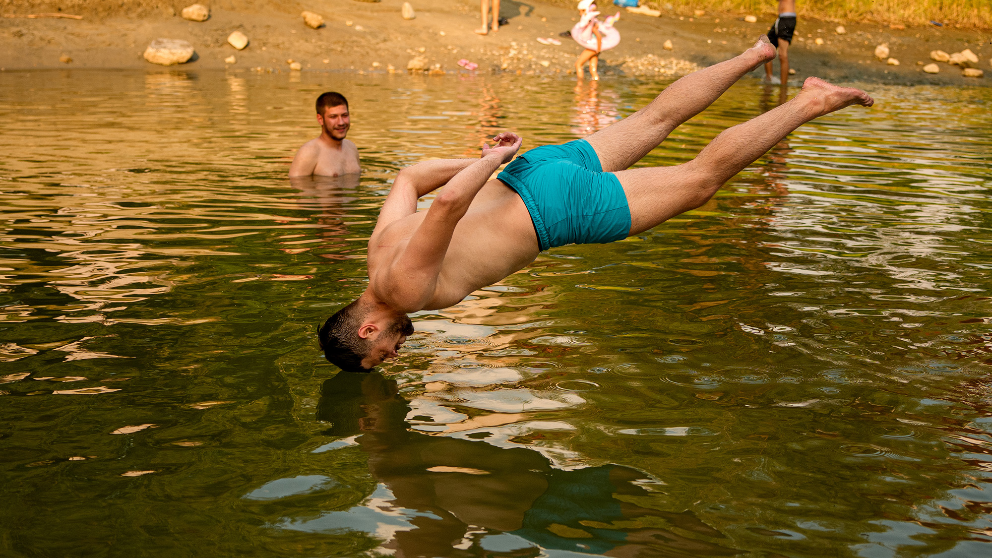 A man jumps headfirst in a river during an extreme heatwave in Romania