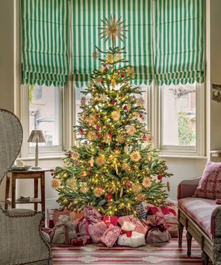 Christmas tree themes 2022 with straw decorations, red baubles and gold lights