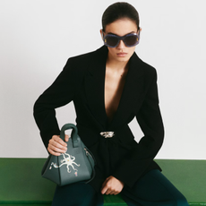 Mytheresa campaign imagery woman wearing black suit and sunglasses