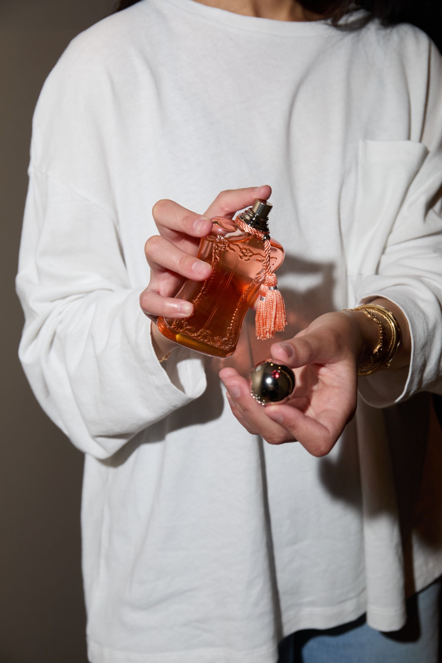 Who What Wear UK junior branded content editor Humaa Hussain spraying a Parfums de Marly perfume