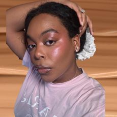 A picture of Ariel Baker with various dewy foundations layered over a swatch of foundation.