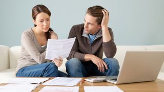 What is zombie debt: image shows couple working through bills