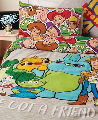 bed with cartoon theme designed cushion and blankets